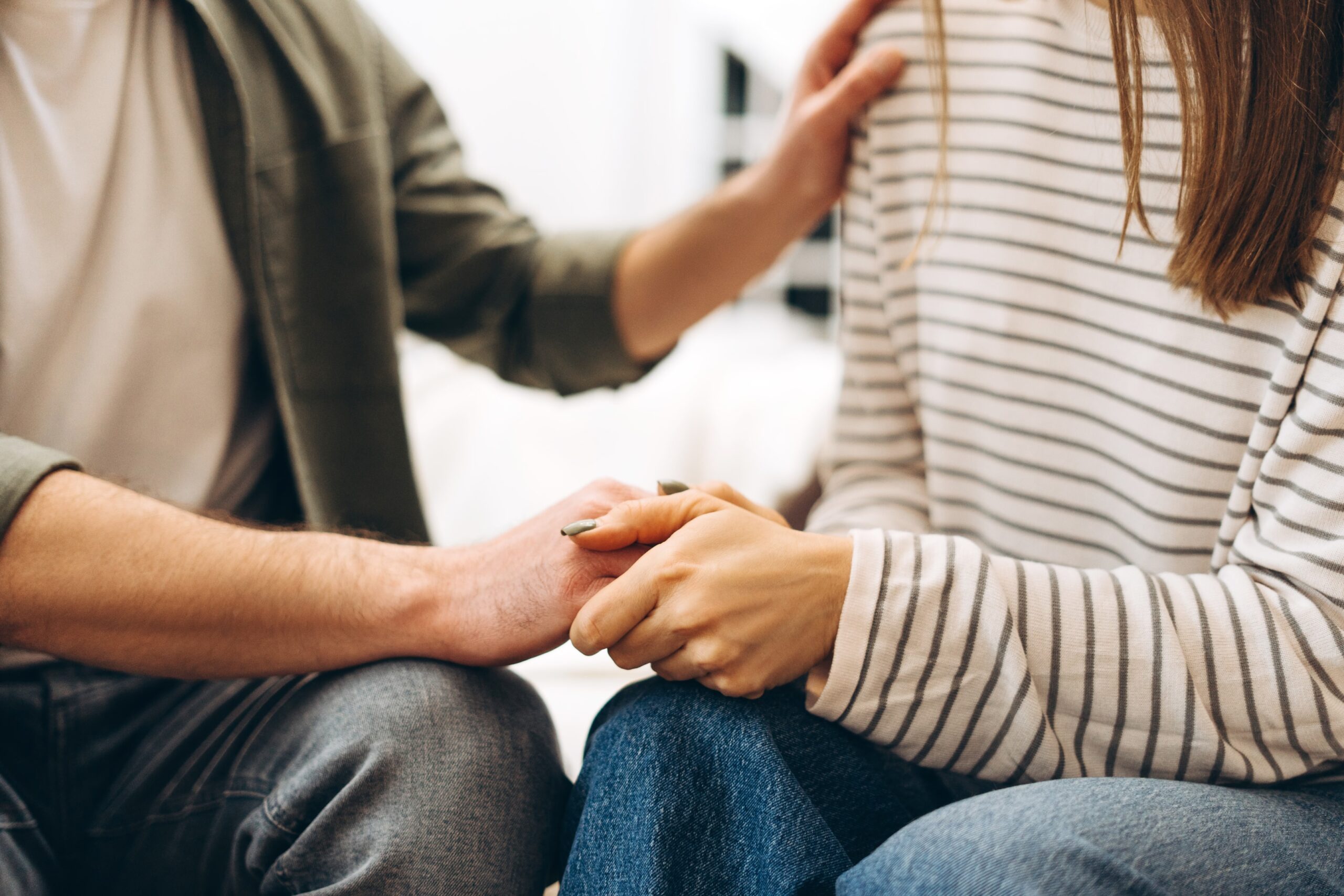 Supportive couple holding hands during IVF consultation, symbolising unity and emotional strength through fertility treatment.